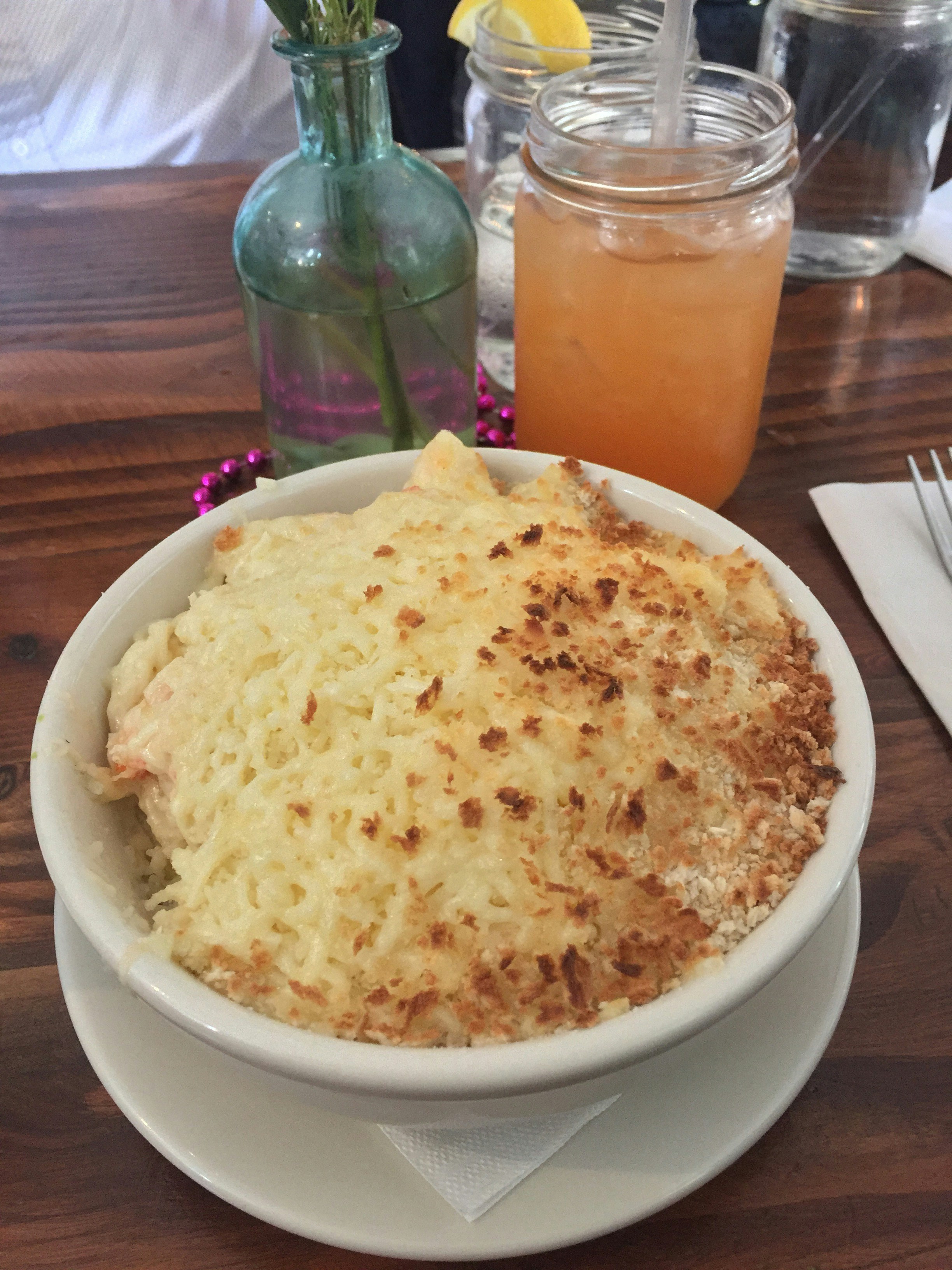 Bubbling golden baked macaroni and cheese in cast iron dish, warm ambient kitchen light, dark rustic setting