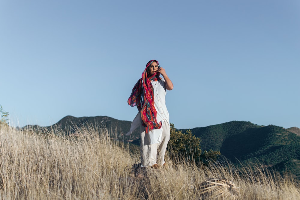 woman in white dress standing on green grass field during daytime