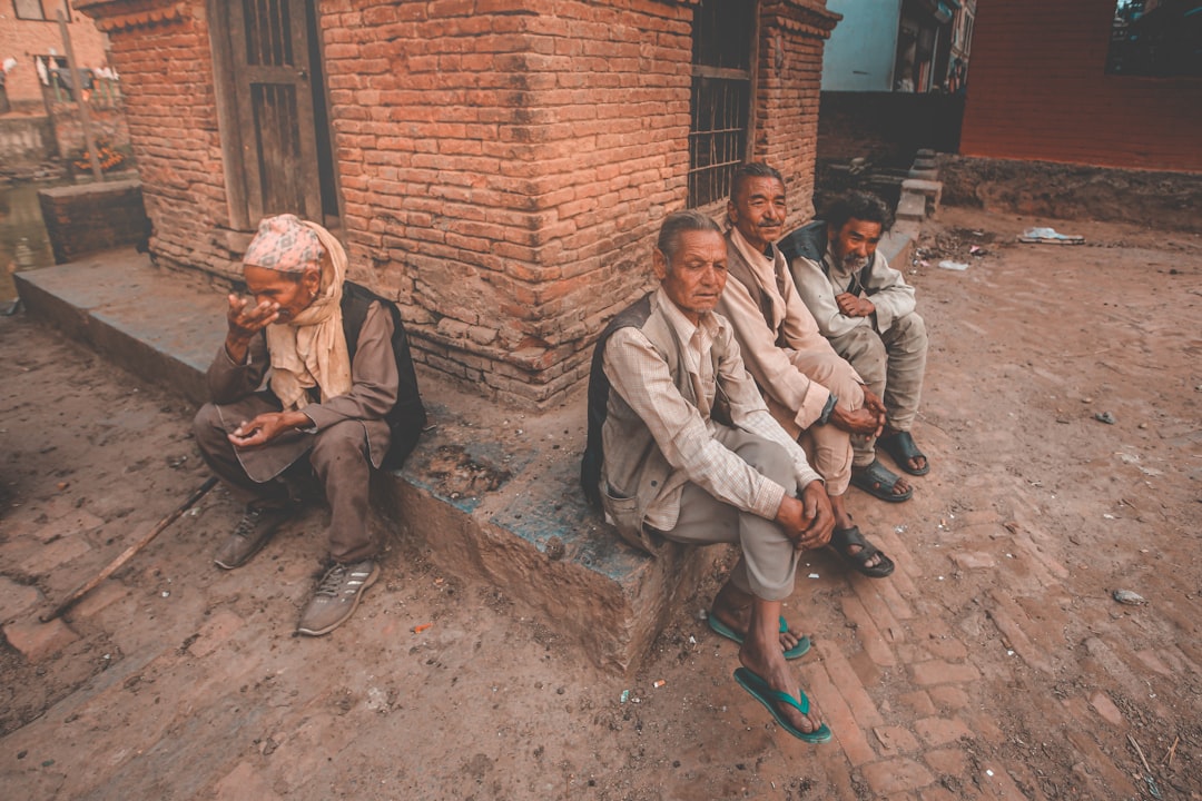 man and woman sitting on brown concrete bricks during daytime