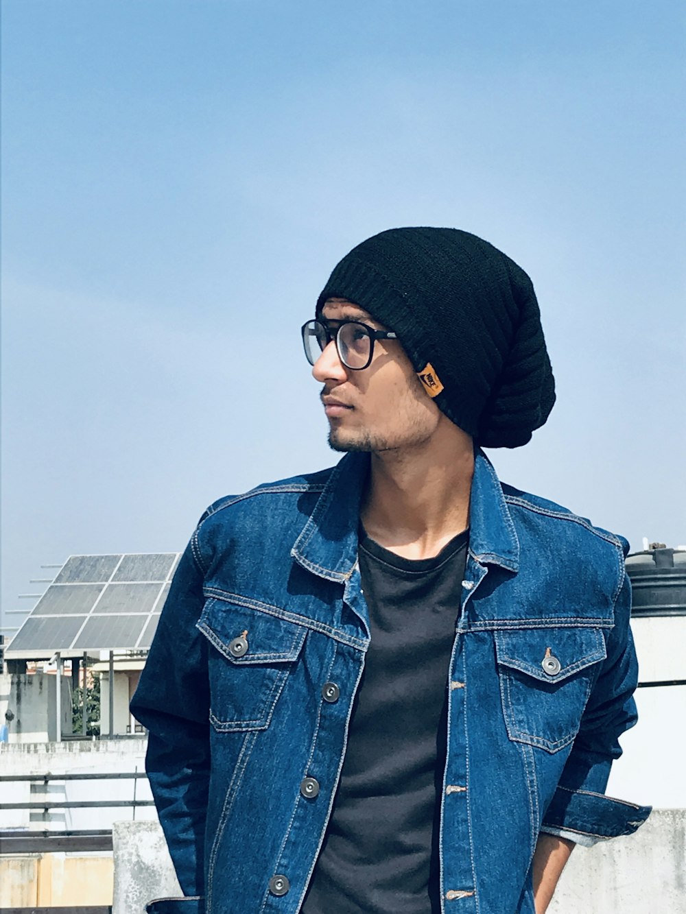 man in blue denim jacket wearing black knit cap and black sunglasses