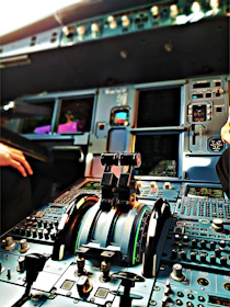 Close-up of hands on a realistic flight yoke and throttle controls inside a home cockpit setup.