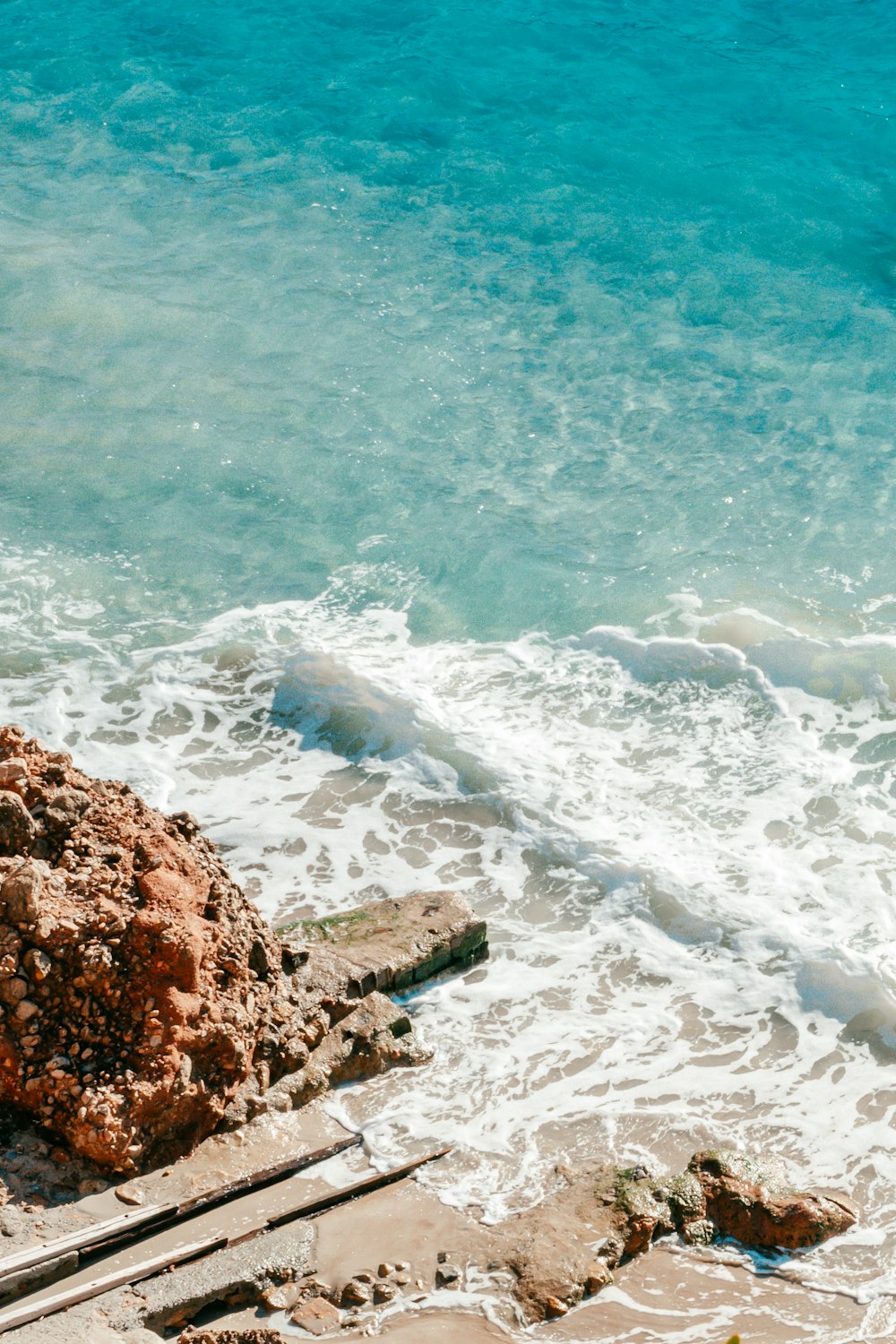 formação rochosa marrom na água do mar durante o dia