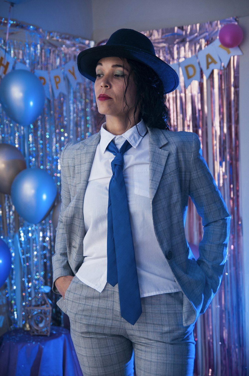 man in gray suit jacket standing near blue balloons