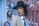 woman in gray and black plaid blazer wearing black hat