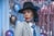 woman in gray and black plaid blazer wearing black hat