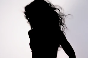 A dynamic image of a model in motion, her hair flowing, set against a sleek black backdrop.