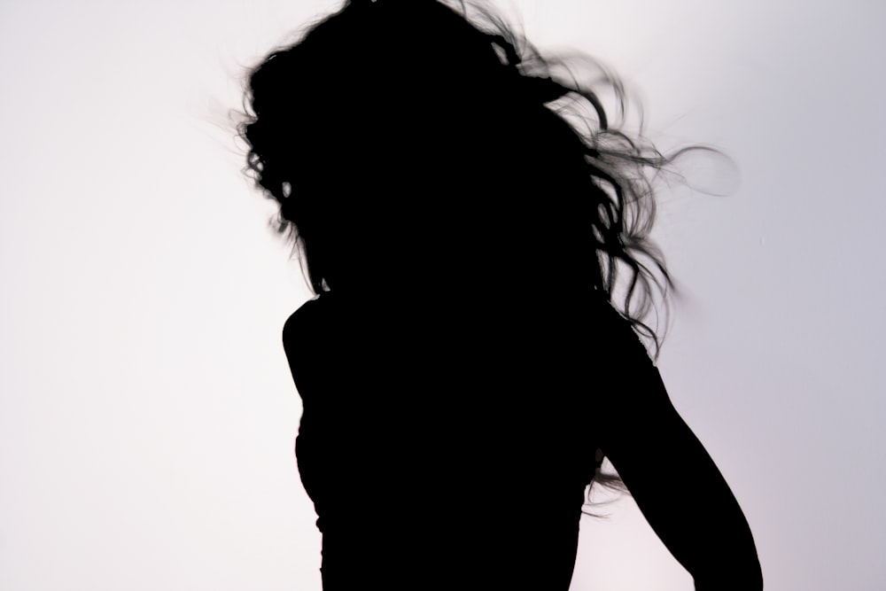 silhouette de femme couvrant son visage avec ses cheveux