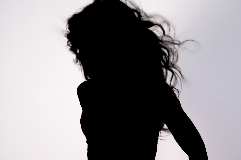 silhouette of woman covering her face with her hair