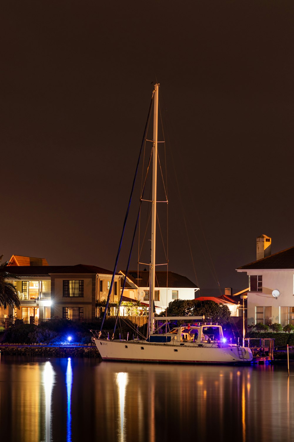 white and blue boat on dock during night time