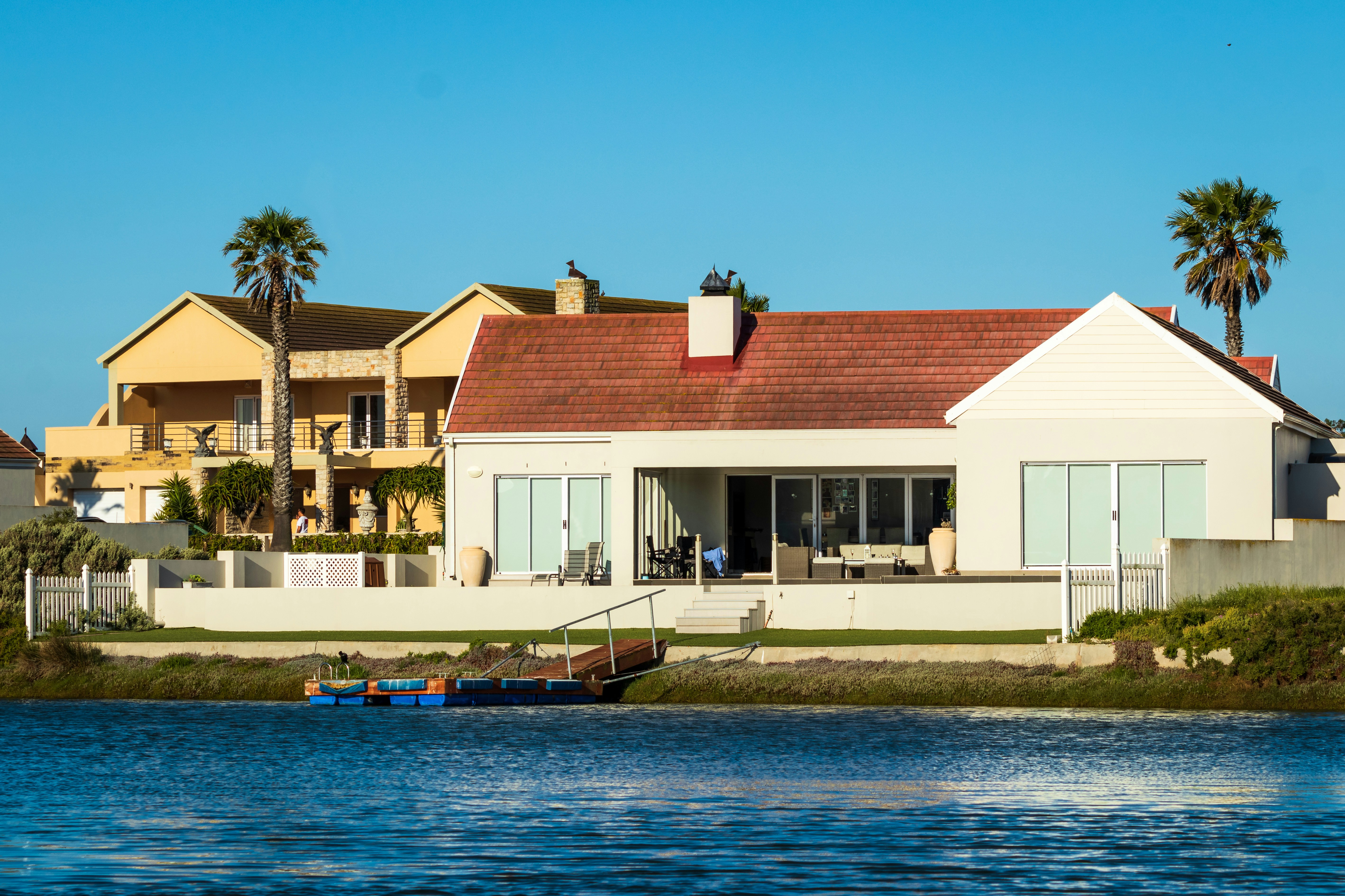 Holiday home on river with palm trees on a sunny day with blue skies