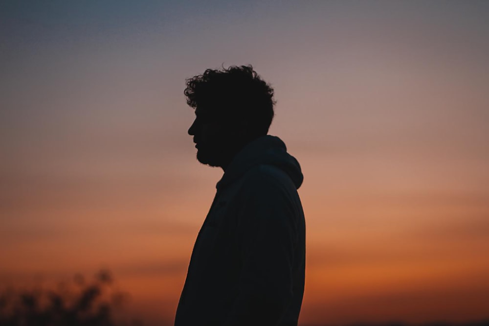 silhouette of man standing during sunset