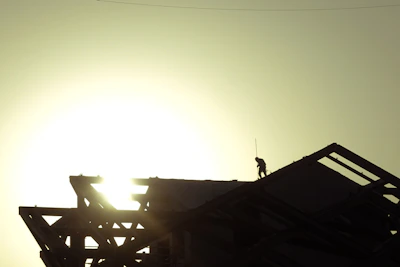A close-up of skilled workers installing a sturdy roof structure on a sunny day.