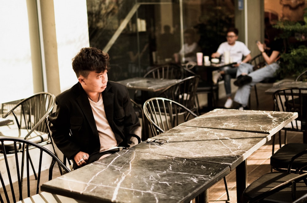 man in black suit sitting on chair