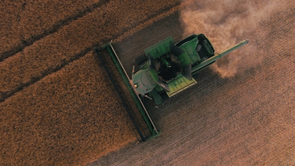 um trator verde está dirigindo através de um campo