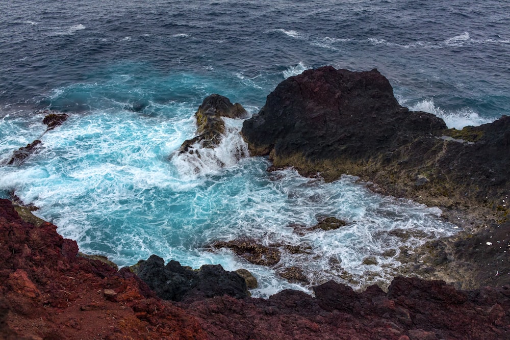 brown rock formation on body of water during daytime