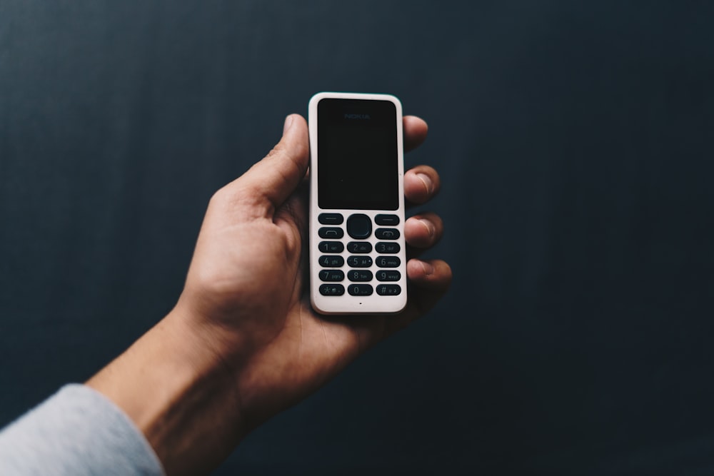 person holding white qwerty phone