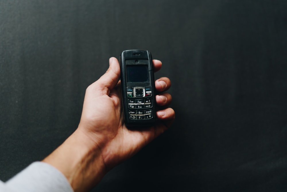 person holding black nokia candy bar phone