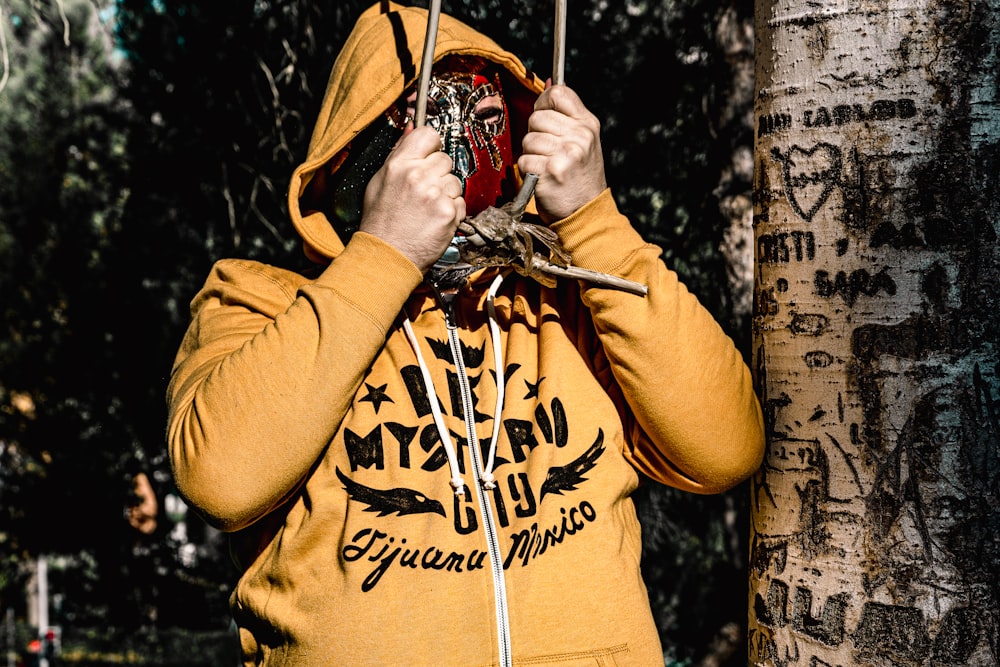 man in brown hoodie with red mask