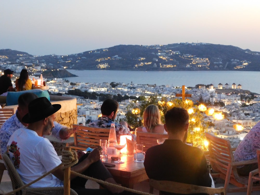 people sitting on chair in front of table with candles on top of it during night