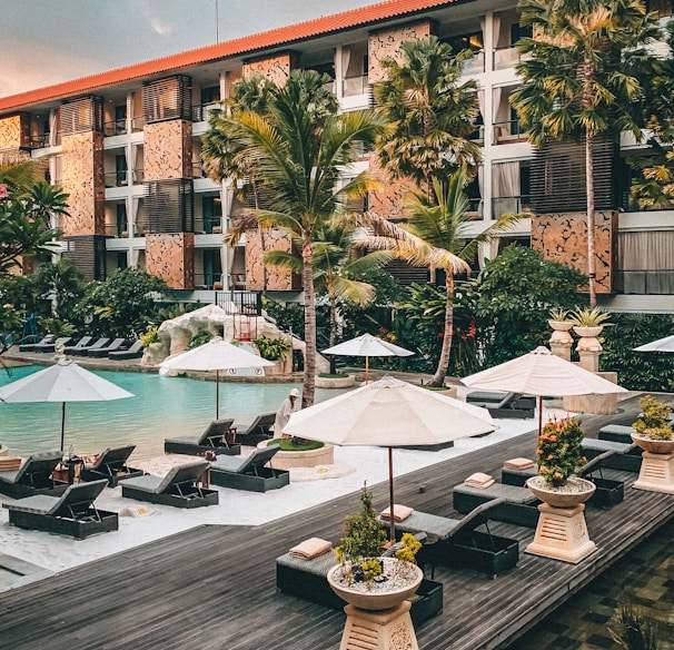 white patio umbrella near swimming pool during daytime