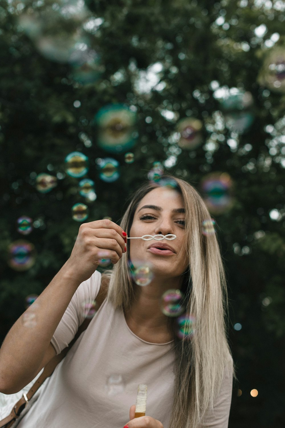 girl in white t-shirt blowing bubbles