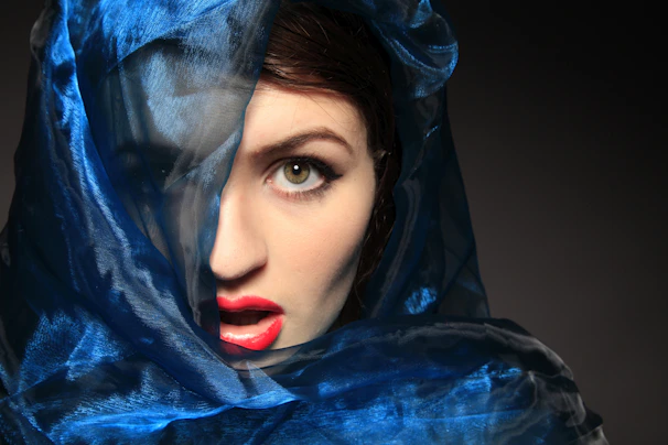 Close-up of a provider’s eyes sparkling with playful mystery, framed by the dark seductive color scheme.