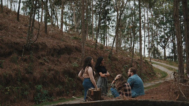 A small group of colleagues in a relaxed meeting outdoors surrounded by nature.