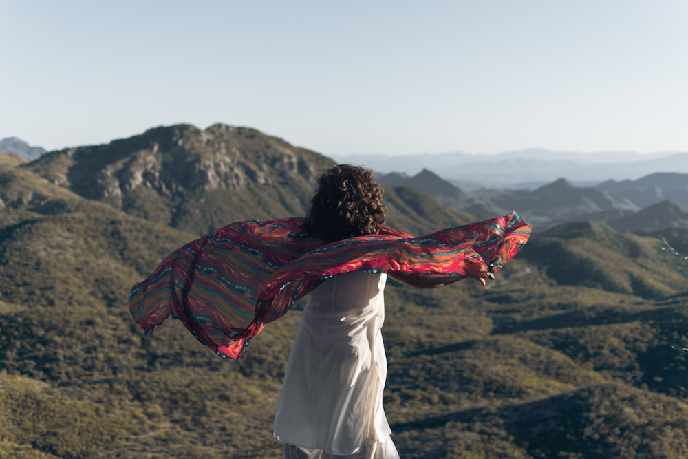 woman in white shirt and red scarf standing on brown field during daytime