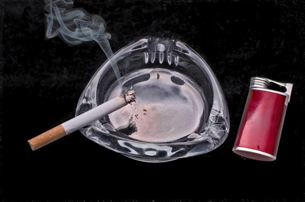 cigarette stick on blue and white ceramic round ashtray