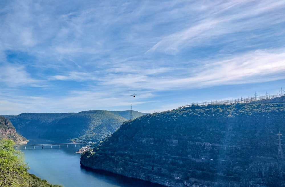 white and black mountain near body of water under blue sky during daytime