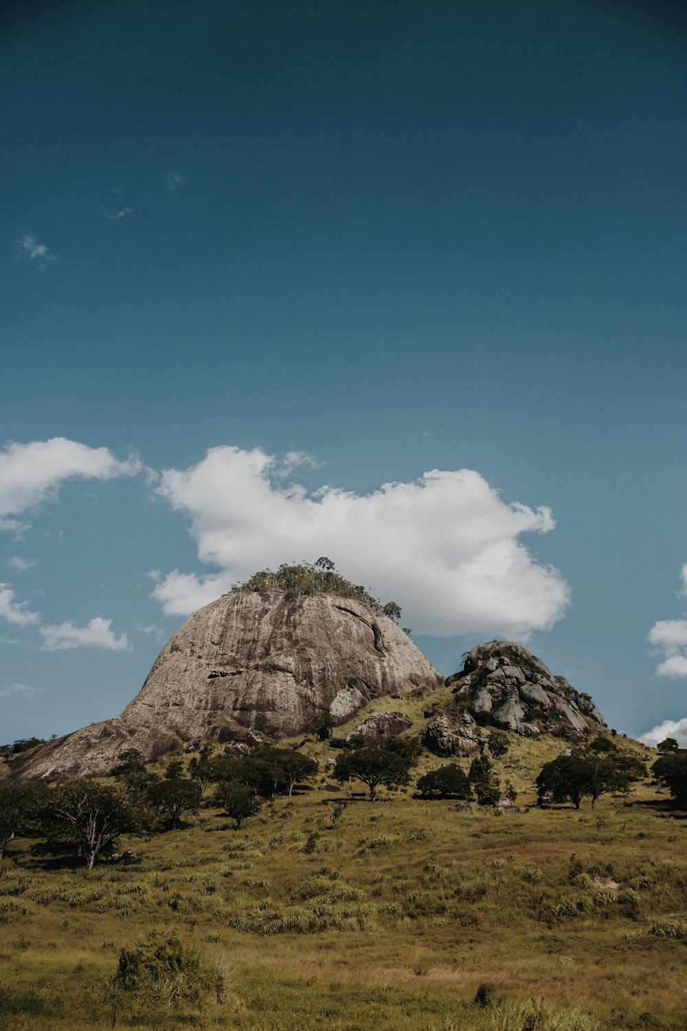 brown rock formation under blue sky and white clouds during daytime