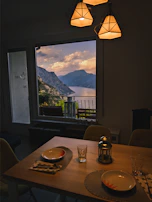 A rustic wooden table set for an intimate Andean cultural meal, surrounded by mountain views.