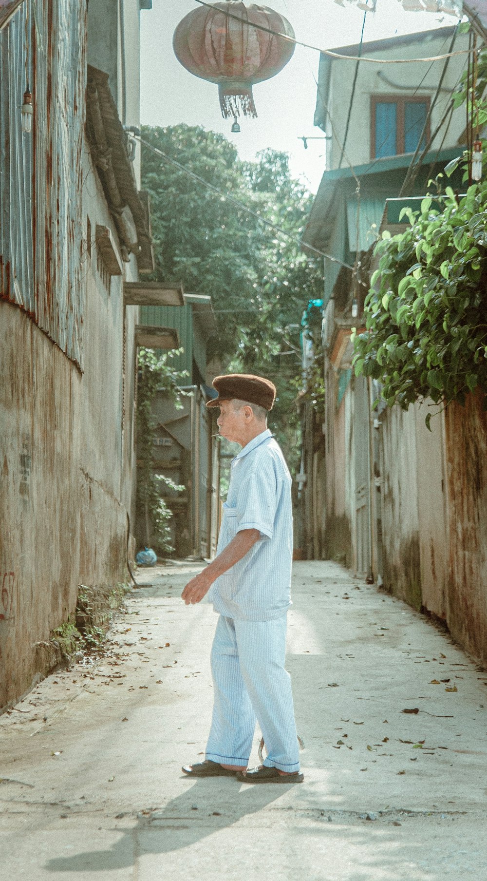 hombre con camisa de vestir blanca y pantalones blancos caminando por el camino durante el día