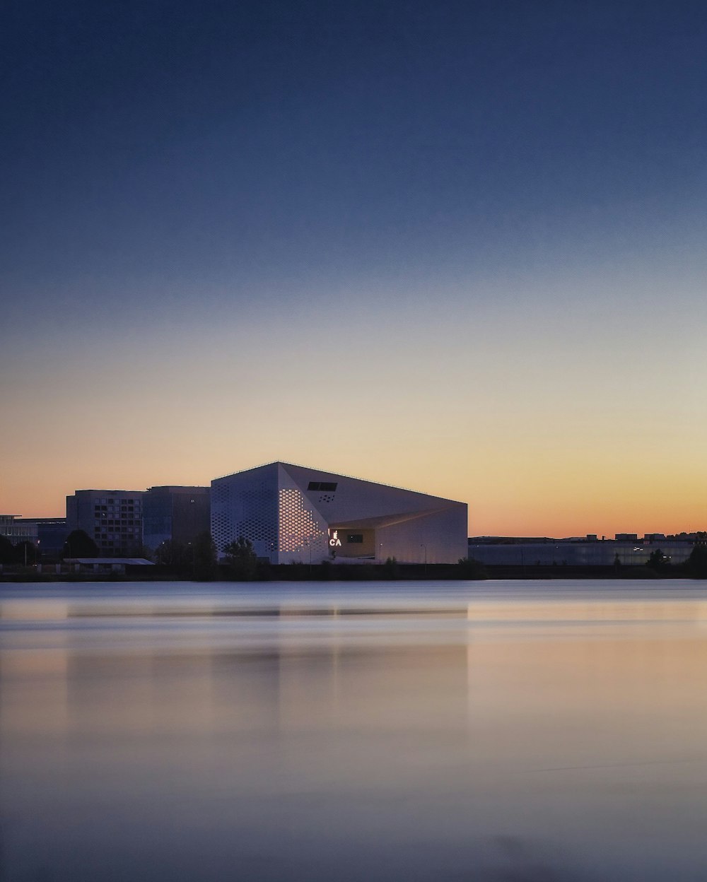 brown and white concrete building near body of water during sunset