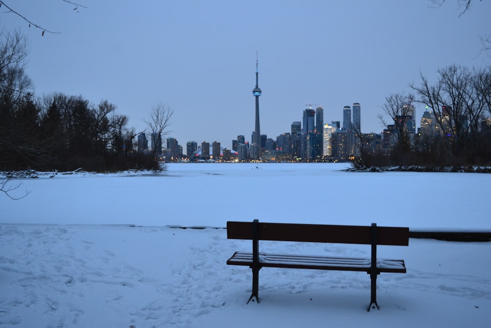 black wooden bench on snow covered ground during daytime