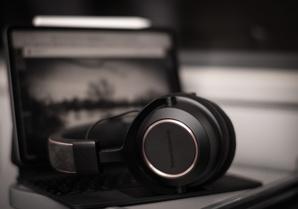 black and silver headphones on black laptop computer