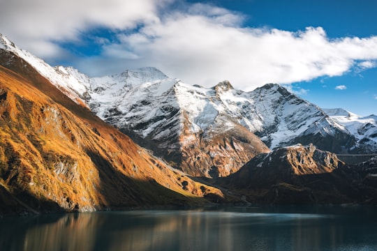 snow covered mountain near lake under cloudy sky during daytime in Kitzsteinhorn Austria