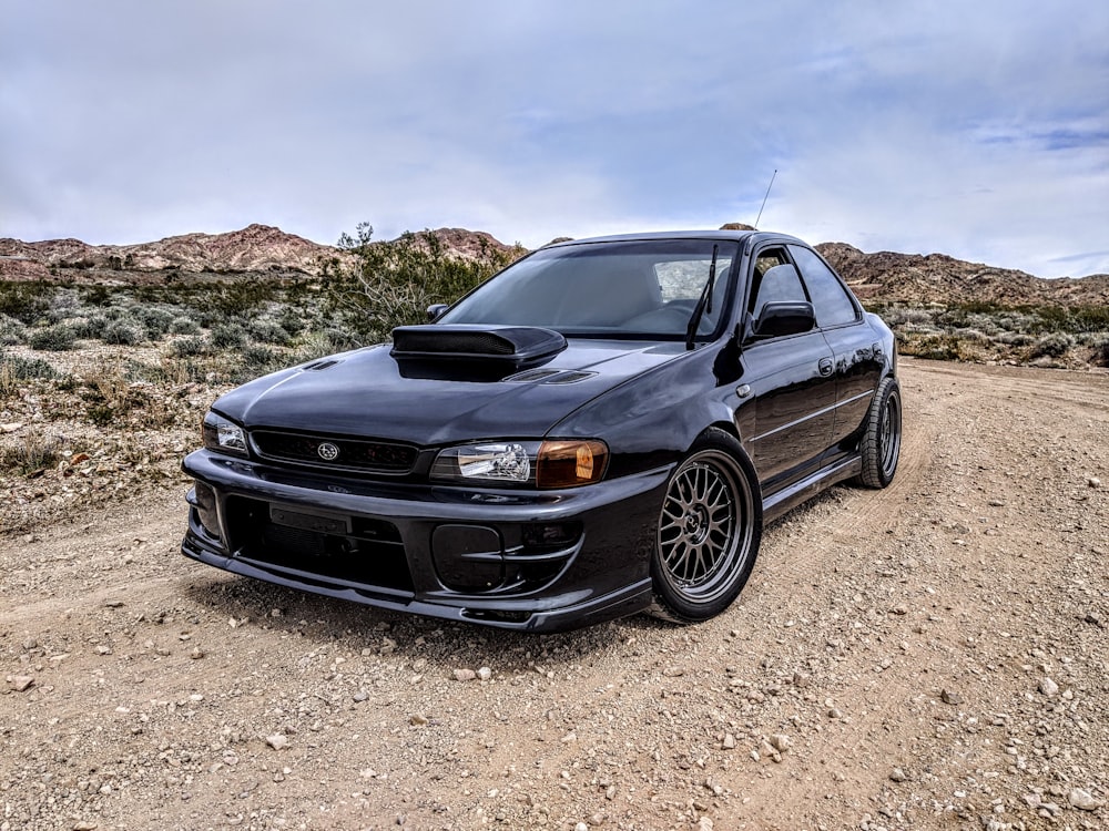 black chevrolet camaro on brown dirt road during daytime