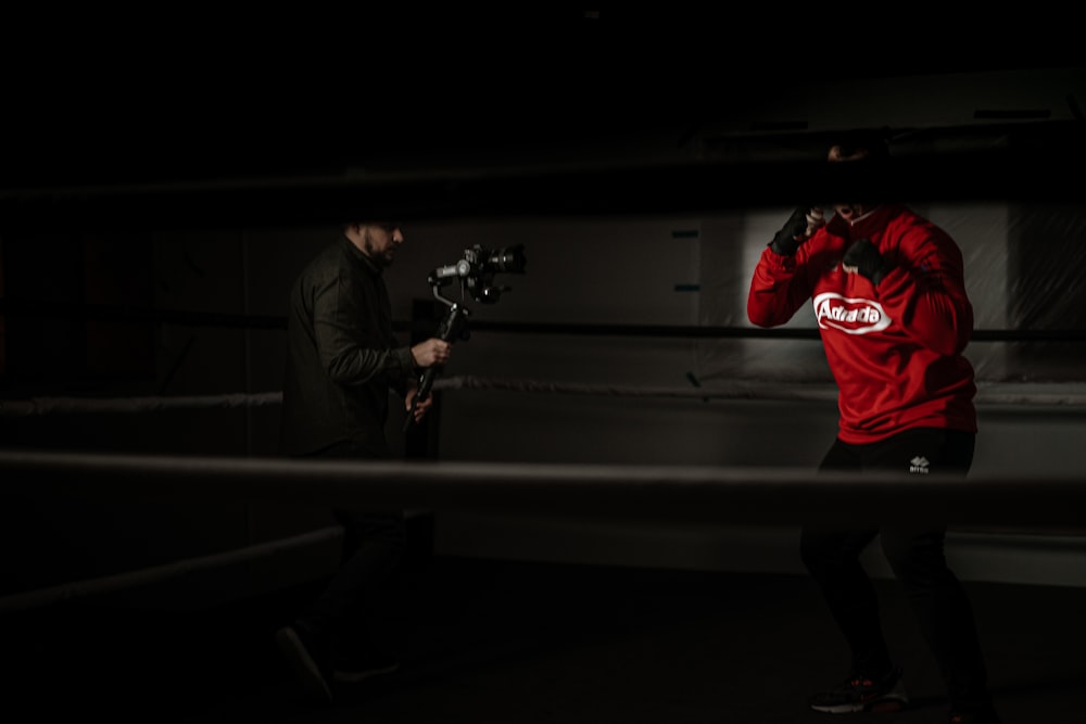 man in red hoodie and black pants playing guitar