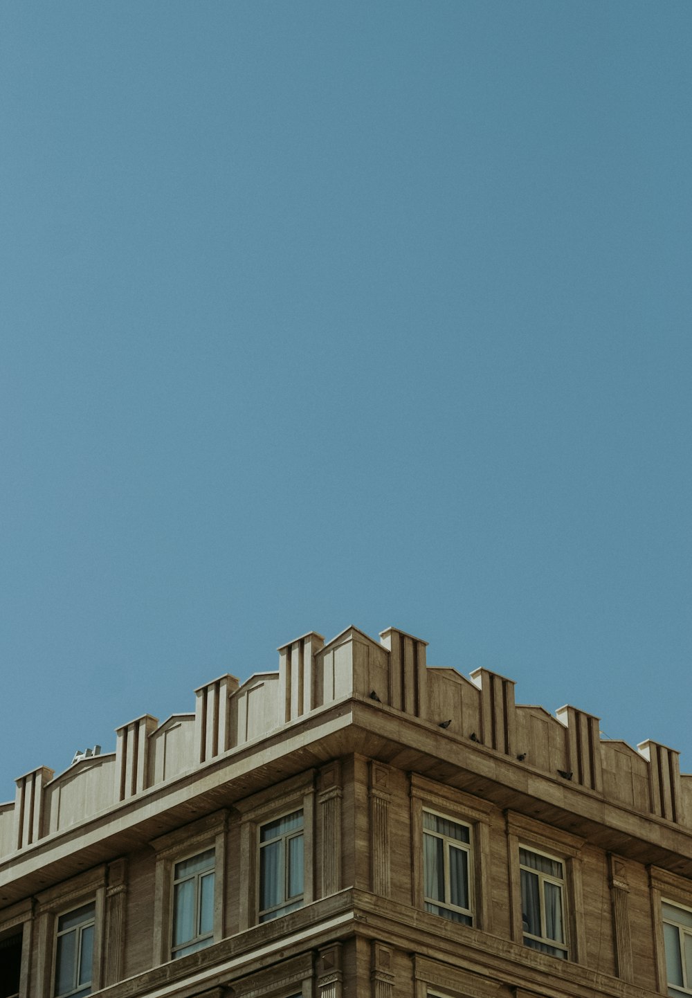 Edificio de hormigón marrón bajo el cielo azul durante el día