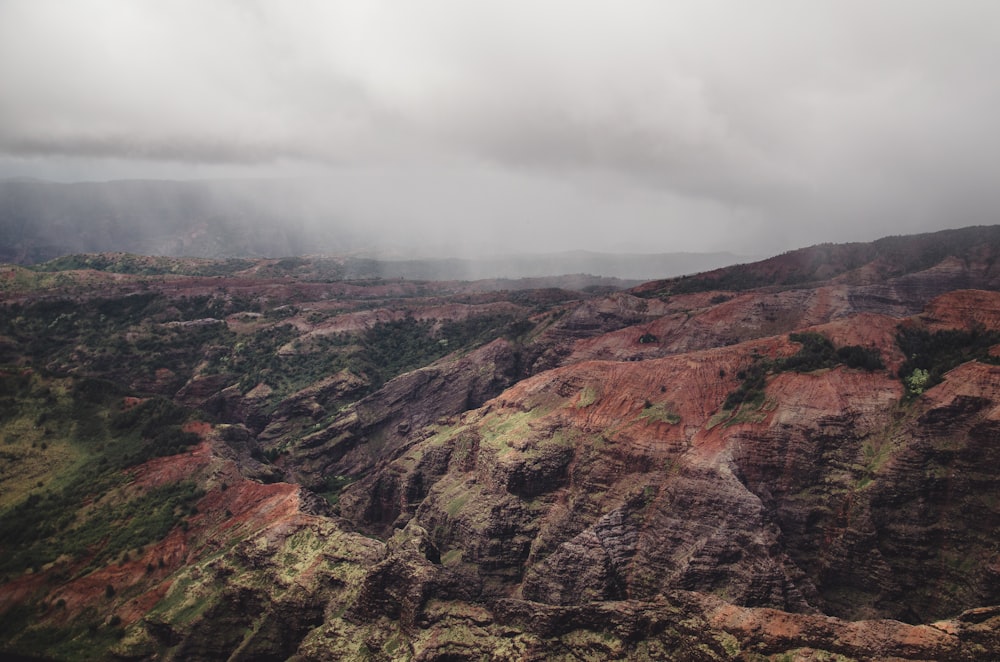 brown and green mountains under white clouds