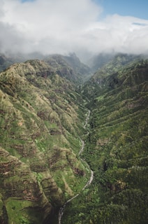An aerial shot of a lush green valley surrounded by mountains.