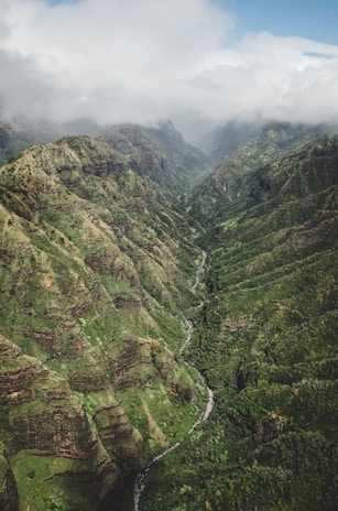 An aerial shot of a lush green valley surrounded by mountains.