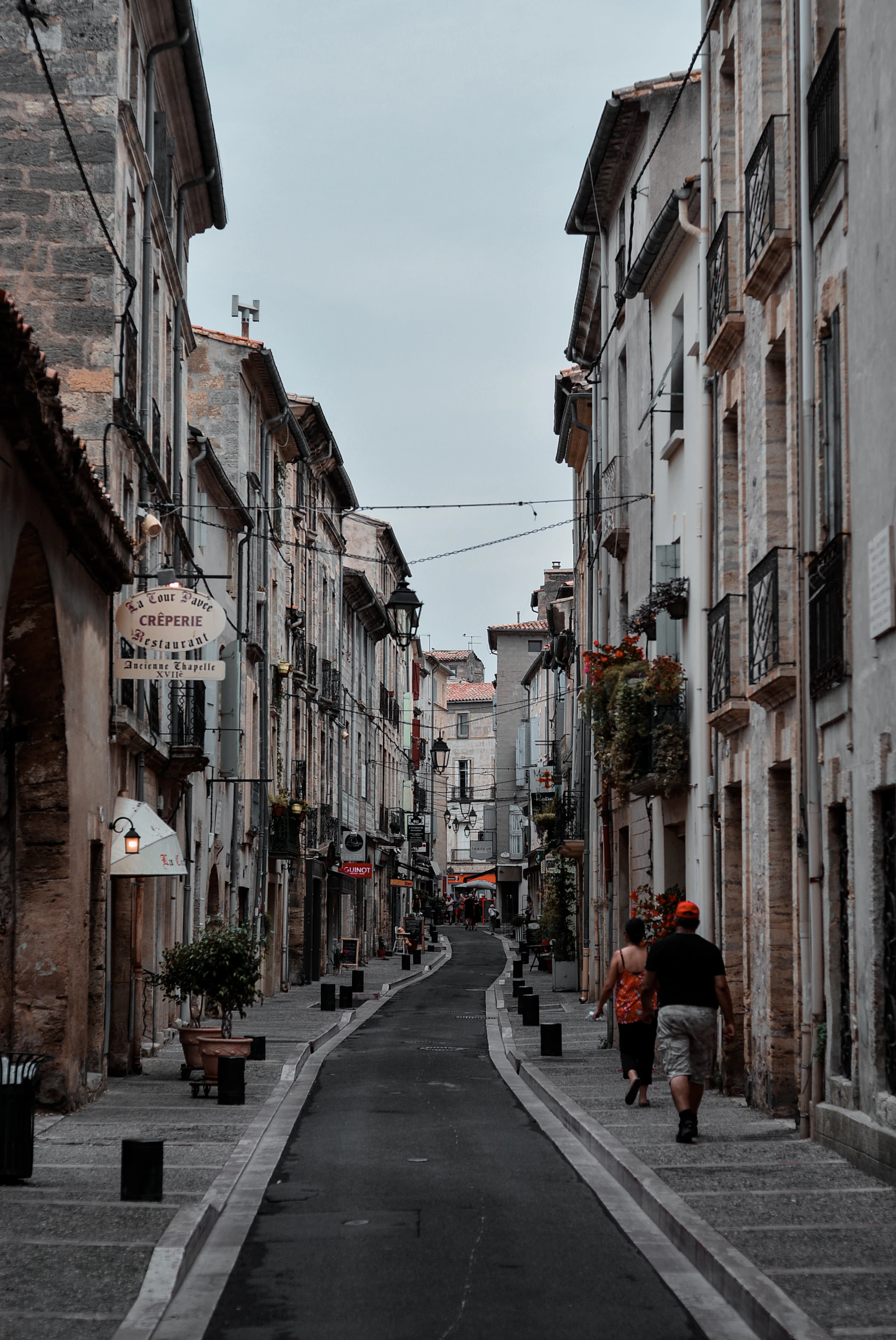man in red jacket walking on street during daytime