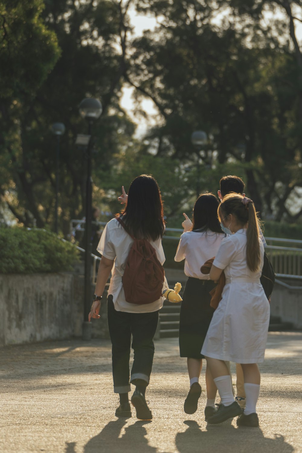 2 women walking on sidewalk during daytime