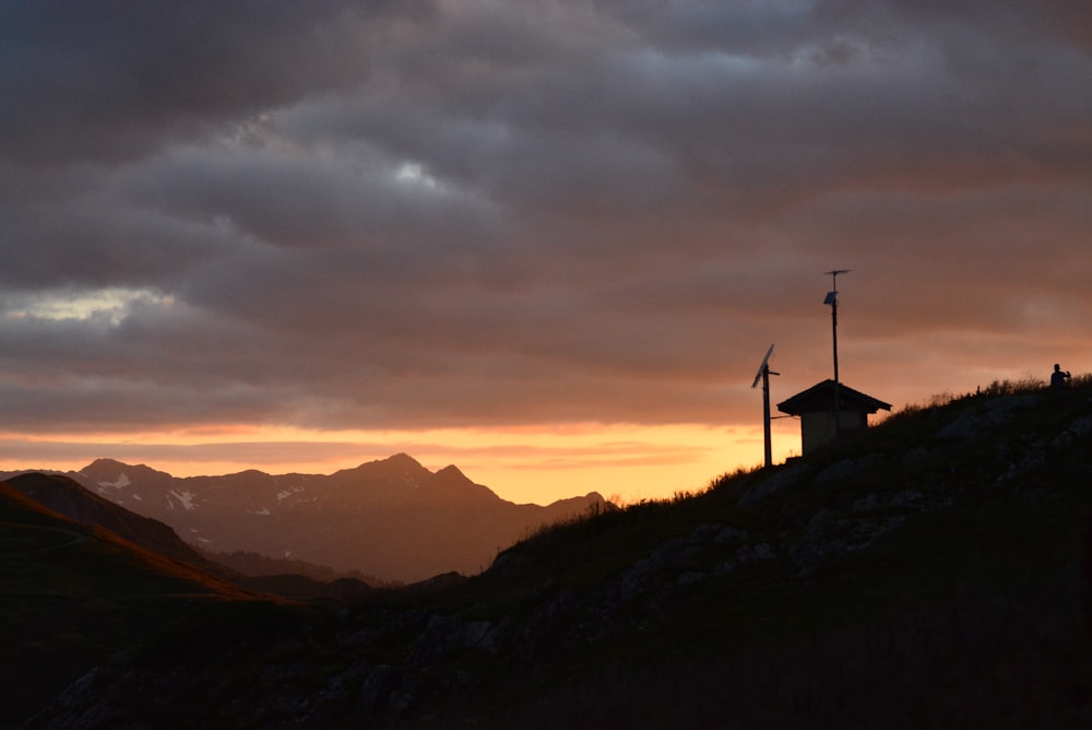 silhouette of wind turbines on mountain during sunset