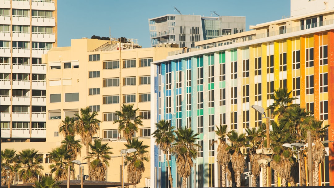 green and white concrete building, Tel Aviv beachfront real estate: hotels and embassies.