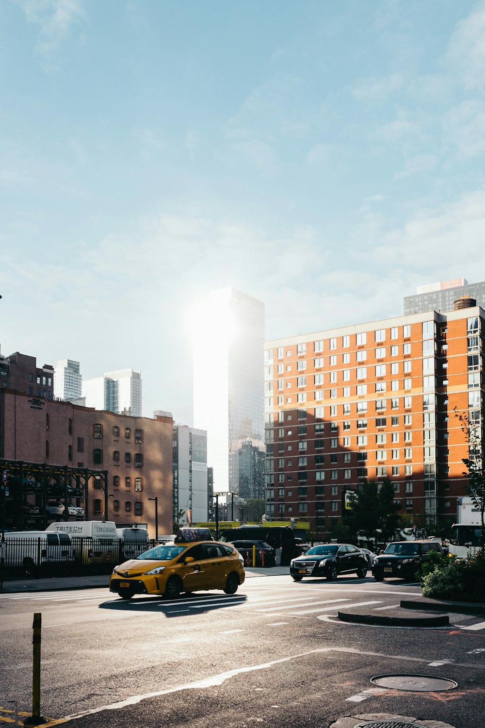 cars parked on side of the road near high rise buildings during daytime