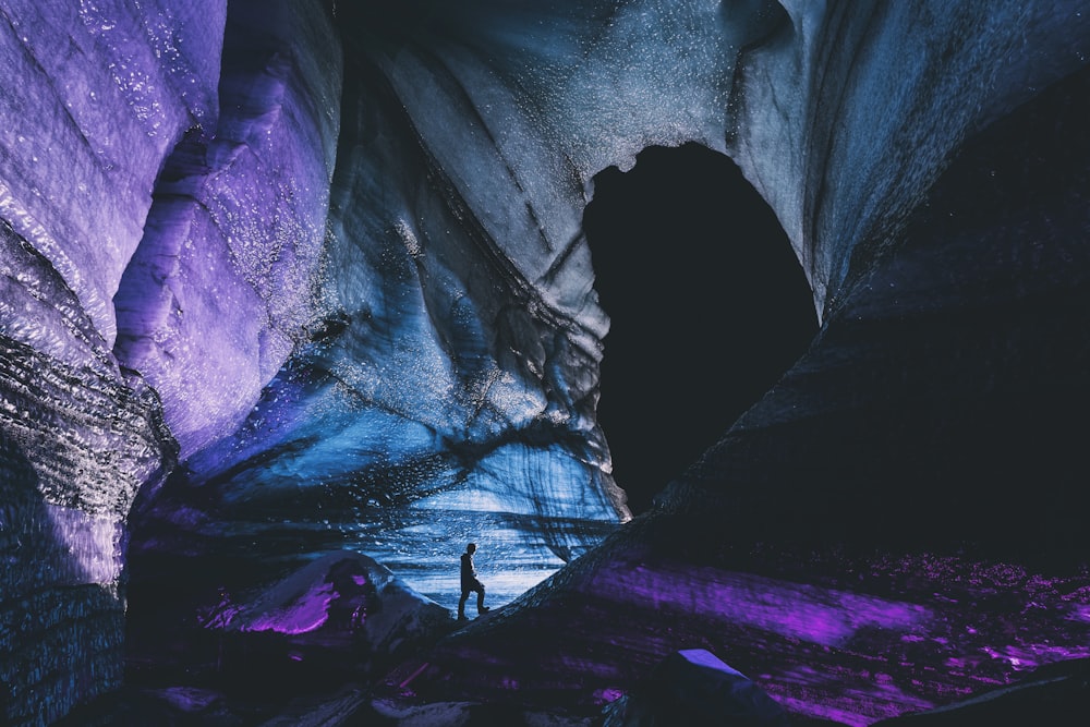 person in black jacket standing on rock formation