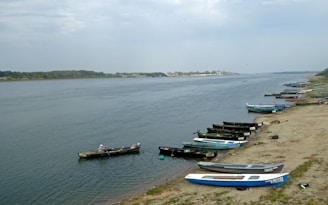 Canoes lined up on a sandy riverbank ready for adventure.